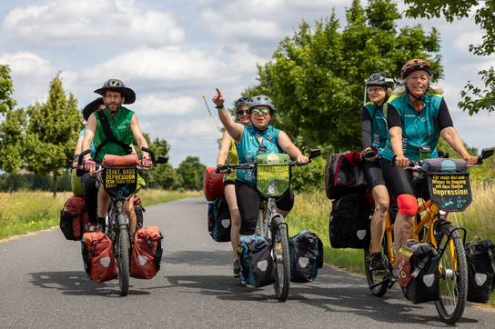Radlerinnen und Radler fahren im Tandem auf einer Straße bei der Mut-Tour. 
